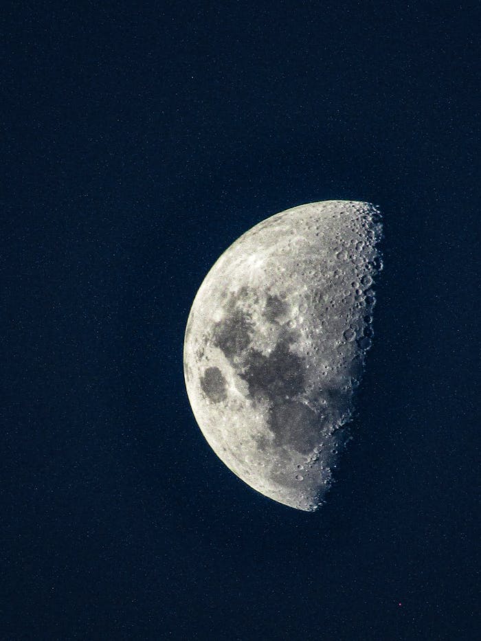 Captivating image of a half moon against a starry night sky, perfect for space enthusiasts.